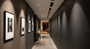 A high-end interior design photograph of a long, narrow modern hallway illuminated by sleek, recesse